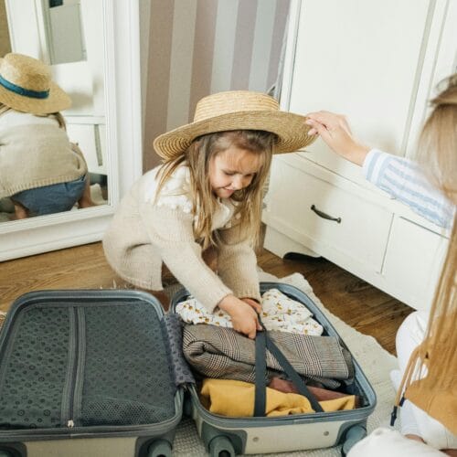 A mother and daughter pack a suitcase for a summer vacation, creating joyful memories.